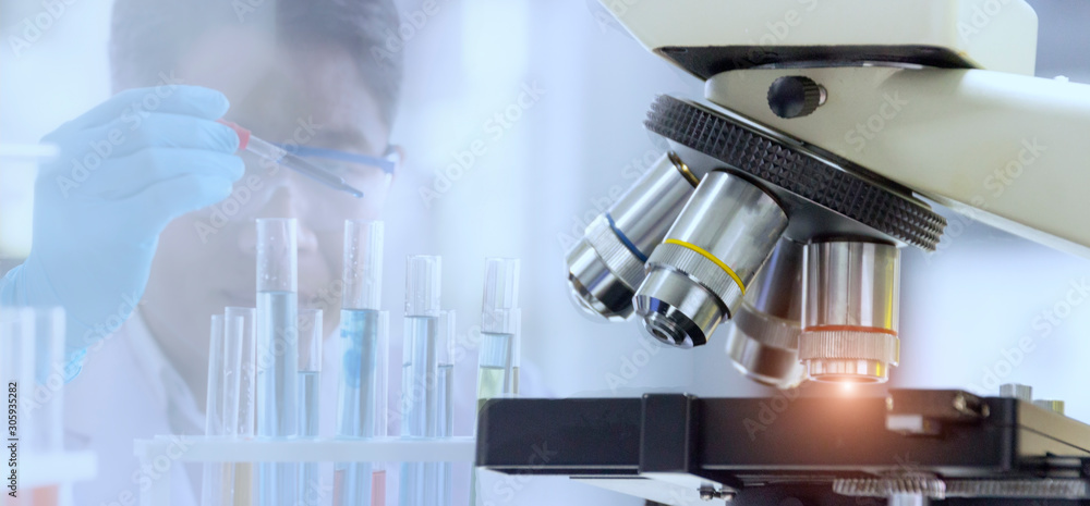 Wall mural laboratory concept: close up of microscope with blurred background of the scientist is researching i