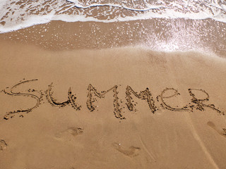 Fototapeta premium Inscription Summer and footprints on the sandy beach