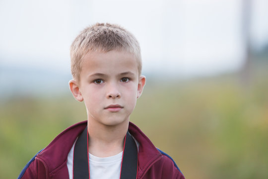 Portrait of a serious child boy outdoors.