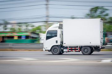 Fototapeta na wymiar Motion image, Small white truck for logistics on the road.
