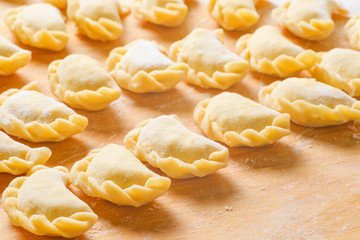 Beautiful delicious dumplings on a wooden Board, cooked at home. Dumplings are a traditional dish of different peoples of the world