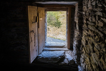 Fototapeta na wymiar The door from the remains of a lonely standing on the river at the foot of the mountains watchtower - Koshki - called the Tower of Love in Svaneti in the mountainous part of Georgia