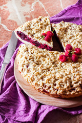 Homemade berry shortcrust pie with crumble on wooden board