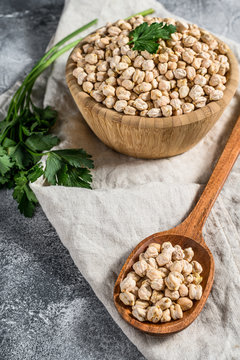 Chickpeas in a wooden spoon. Healthy vegetarian food. Gray background. Top view
