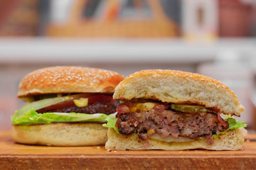 two homemade hamburgers with vegetables. Hamburger in focus sliced