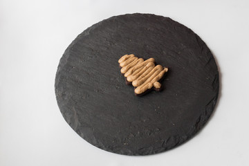 homemade chocolate chip cookie with a caramel layer in the shape of a Christmas tree on a black tray
