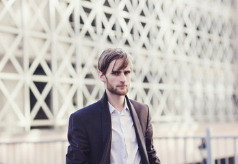Fototapeta premium portrait of a successful man in a suit on the background of a modern building