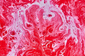 Abstract psychedelic liquid red and white acrylic paints mix in a swirl flow. Sea ocean wave...