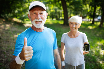 Beautiful mature couple jogging in nature living healthy