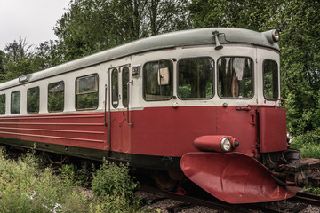 Fototapeta na wymiar Old abandoned rail bus standing on an overgrown track