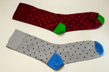 Pair of colorful socks of different colors, lie on white surface. Not isolate.