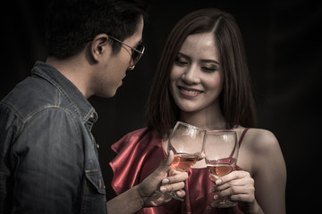Happy new year celebration, Asia couple hand holding glasses of whisky making a toast and drinking together at the party, happy time, celebration concept.