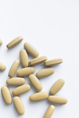Scatterded yellow pills on white background 