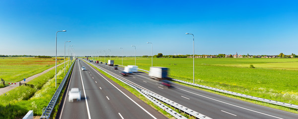 Highway through grassy fields on a sunny day, The Netherlands