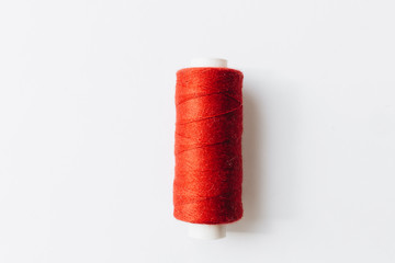 Red sewing thread on background