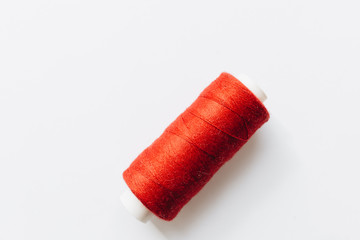 Red sewing thread on background