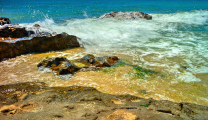 Fototapeta na wymiar Beautiful landscape with rocks and sea waves on a sunny beach