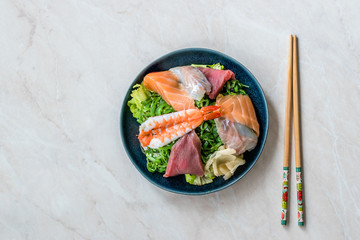 Sashimi Salad with Wakame, Seaweed, Salmon, Sea Bass, Shrimp, Kani, Mackerel Fish, Tuna served with Chopsticks.