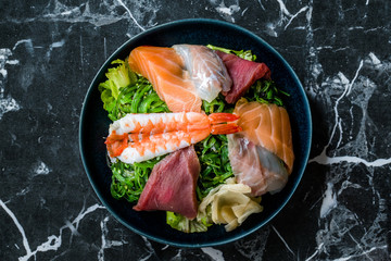 Sashimi Salad with Wakame, Seaweed, Salmon, Sea Bass, Shrimp, Kani, Mackerel Fish, Tuna served with Chopsticks.