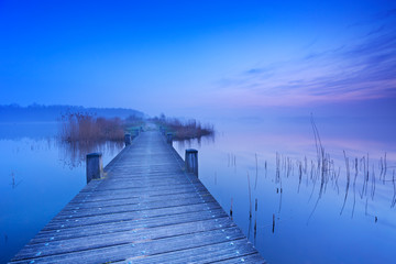 Fototapeta na wymiar Boardwalk over water at dawn in The Netherlands