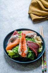 Sashimi Salad with Wakame, Seaweed, Salmon, Sea Bass, Shrimp, Kani, Mackerel Fish, Tuna served with Chopsticks.