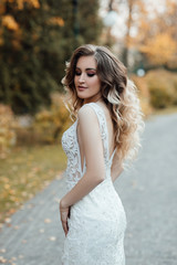 Female fashion. Beautiful fashion woman, model with shiny healthy long volume hair. Waves curls updo volume hairstyle. Makeup. Girl with luxurious haircut. Young woman enjoying autumn weather.