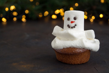 Christmas chocolate cupcakes with snowman decor. on dark background.