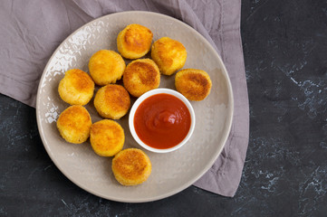 breaded fried potato balls with tomato sauce