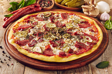 Meat and vegetable pizza on wooden table close up