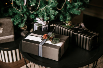 many beautiful Christmas presents lie under the tree on the floor.