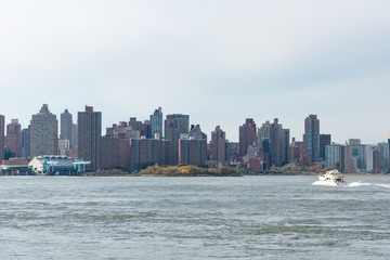 Fototapeta premium Upper East Side Skyline in New York City with Residential Skyscrapers and the East River with a Boat