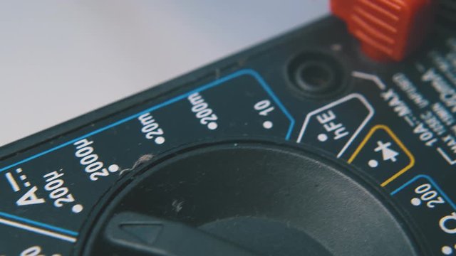 multimeter with connected probes and data on screen lies on clean white background extreme close view