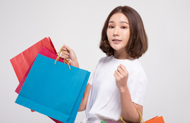 Shopping Asian woman with short hairs smile and Holding Shopping bags, Cheerful and happiness emotional, Enjoy Shopping in black friday sale, Isolated on gray background, Shopping Concept