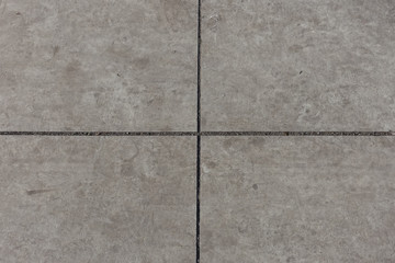 Crossed joints between light grey concrete slabs