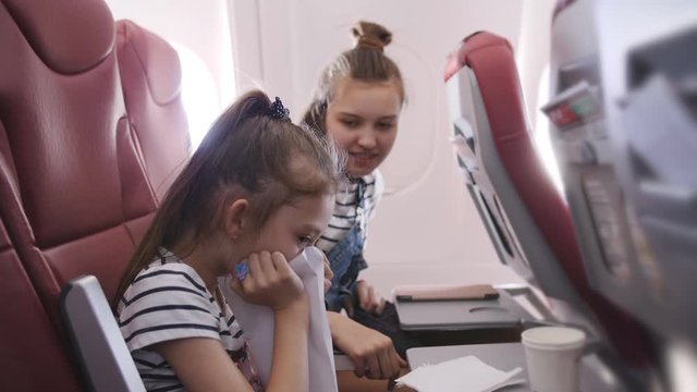 Little girl on the plane vomited in a paper bag. A Little girl feels bad in the cockpit. The fear of flying.