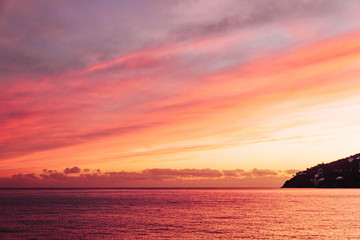 Fototapeta na wymiar Gorgeous wallpaper sundown background at Amalfy coast, Italy with magnificent luminous colors