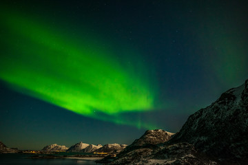 Fototapeta na wymiar beautiful aurora borealis, polar lights, over mountains in the North of Europe - Lofoten islands, Norway
