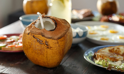 opened coconut with a straw on the table among healthy food, natural Breakfast in morning