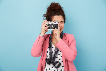 Image of woman with footage over neck taking photo on retro camera