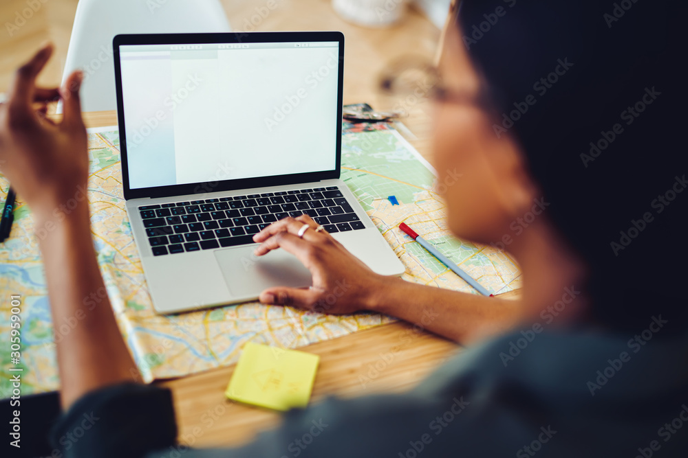 Poster back view of african american woman using modern technology and map for planning route and adventure