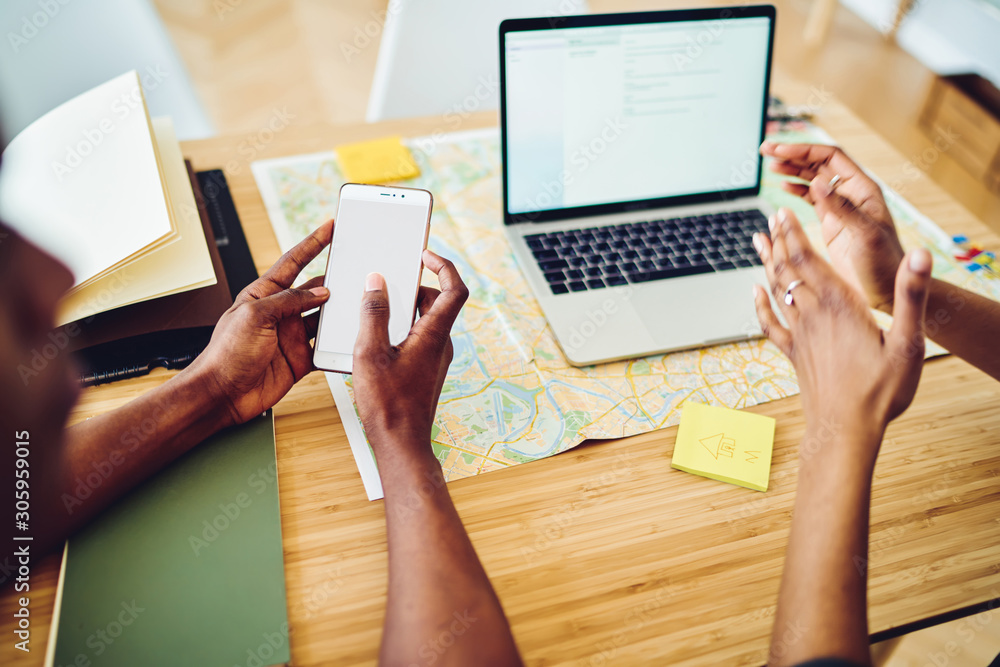 Poster close up view of young make person holding smartphone with copy space screen over table with map and