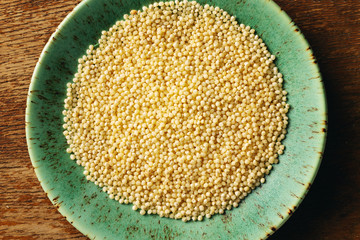 Millet dry seeds in bowl, top view 