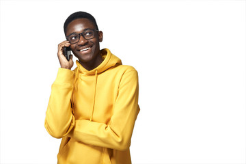 young black man in yellow hoodie with phone