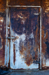 horizontal closed very rusty iron door with a deadbolt, the texture of rust