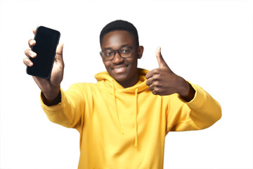 young black man in yellow hoodie with phone
