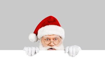 Santa claus with a blank card on gray background