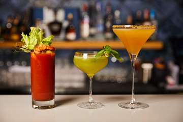 mixed and fresh cocktails in glasses on bar counter