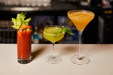 mixed and fresh cocktails in glasses on bar counter