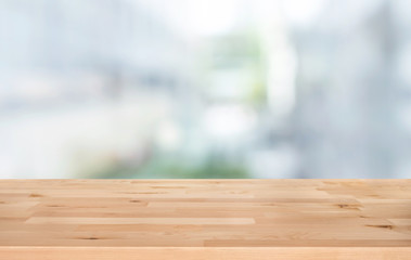 Selective focus of wood table top on white wall glass (big window) background