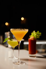 selective focus of fresh cocktails in glasses on bar counter